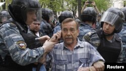 Riot police detain human rights activist Lev Ponomaryov during an unsanctioned protest in Moscow on May 7.