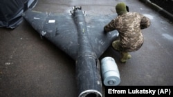 Український військовий показує знешкоджений росйський дрон із термобаричною частиною, фото ілюстративне