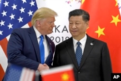 На цьому фото від 29 червня 2019 року президент США Дональд Трамп (ліворуч) тисне руку голові КНР Сі Цзіньпіну під час зустрічі на полях саміту G-20 в Осаці, Японія