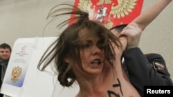 A policeman detains a protester in Moscow in March.