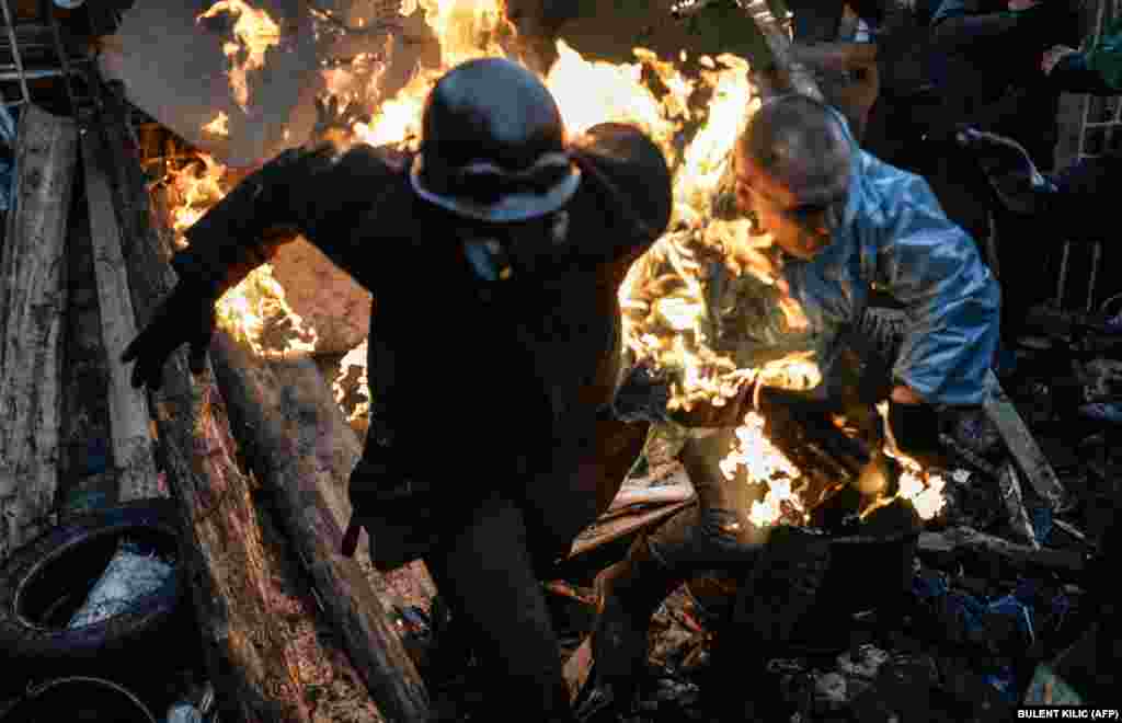 Protesters catch fire as they stand behind burning barricades during clashes with police in Kyiv on February 20. Numbers vary, but Euromaidan activists say around 100 protesters were killed in total during the antigovernment protests.