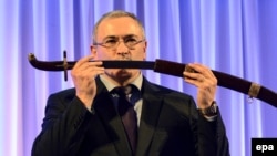 Russian former oil tycoon Mikhail Khodorkovsky receives a replica of a saber after he was awarded with the Knight of Freedom award by the Kazimierz Pulaski Foundation in Warsaw on December 3.