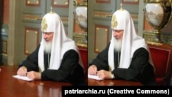 Патріарх РПЦ Кирило зі своїм дорогим годинником, який на фото після скандалу заретушували, однак залишилось його віддзеркалення на стол
