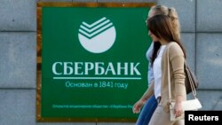 Women walk past a Sberbank office in Moscow on September 12.