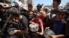 Palestinieni adunați la un punct de distribuire a alimentelor la tabăra de refugiați Nuseirat. 19 iulie 2025. 