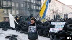 A protester shouts to riot police in front of a barricade during an antigovernment protest in downtown Kyiv.
