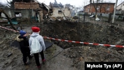 Діти дивляться на воронку після російського ракетного обстрілу. Село Солонка, Львівська область, 16 листопада 2022 року