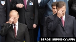 Володимир Путін (ліворуч) і Віктор Янукович (праворуч) хрестяться під час богослужіння, приуроченого до 1025-річчя Хрещення України-Русі. Київ, 27 липня 2013 року