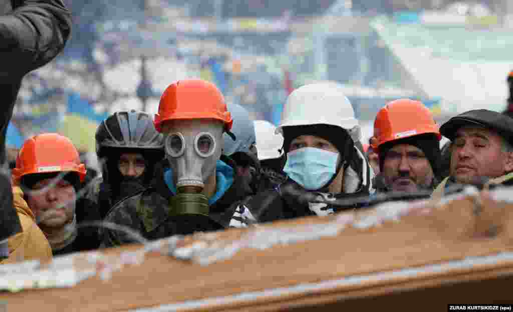Pro-European protesters stand on a barricade built to block the way to Independence Square in Kyiv on December 9.