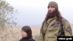 A child militant is shown killing two men identified as “Russian agents.” 
