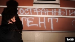 Человек проходит мимо надписи "Иностранный агент" на стене здания, в котором находится офис правозащитного центра "Мемориал". Москва, 21 ноября 2012 года.