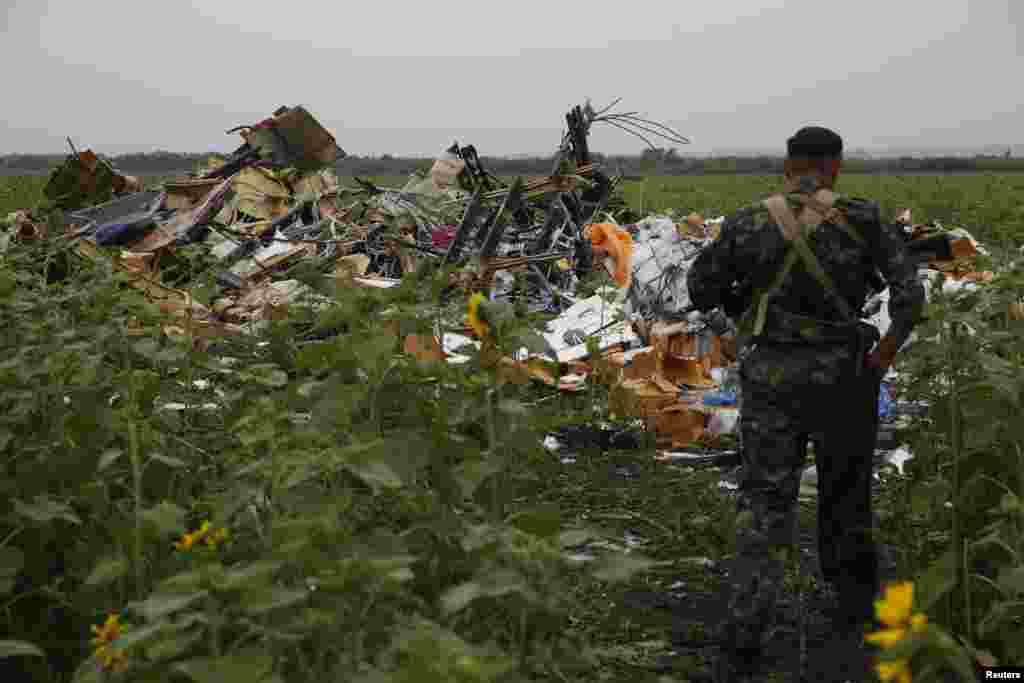 Another pro-Russian separatist looks at wreckage from the nose section of the airliner near the village of Rozsypne on July 18. 