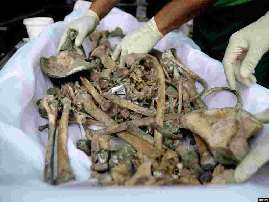 Workers pack the remains of victims from the 1995 Srebrenica massacre in a coffin at a morgue in the central Bosnian town of Visoko in July 2010.