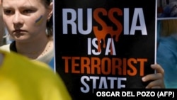 Молода українка з плакатом «Росія – держава-терорист» на акції протесту проти російської агресії щодо України. Мадрид, Іспанія, 29 червня 2022 року (ілюстраційне фото)