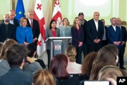 Georgian President Salome Zurabishvili (center), surrounded by opposition leaders, speaks to the media in Tbilisi on October 27, a day after the parliamentary elections.