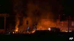 Rescue workers extinguish a fire at the site of a Russian drone attack in Kharkiv early on April 6.