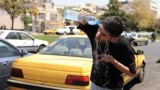An Iranian taxi driver cools down by splashing water on his face on a street amid soaring temperatures in Tehran on July 22.