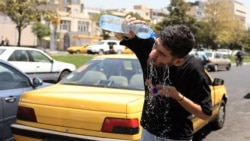An Iranian taxi driver cools down by splashing water on his face on a street amid soaring temperatures in Tehran on July 22.