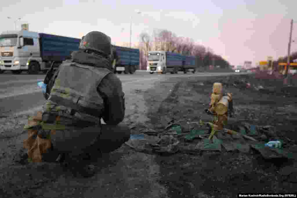 A Ukrainian soldier crouches next to an anti-tank missile at the scene of the battle on the outskirts of Kharkiv. 