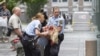 Полицейские выносят пострадавшую женщину с места взрыва в Осло. 22 июля 2011 г