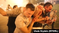 Demonstrators carry an injured man in Minsk during a protest after voting ended in the Belarusian presidential election on August 9. Months of protests followed the reelection of Alyaksandr Lukashenka to a sixth term in a vote widely seen as illegitimate.