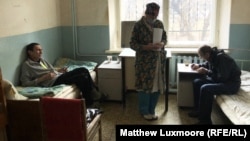 A nurse treats Ivan Korobenkov (left) and another TB patient at the treatment center in Chernavsky. Doctors at the center say they are forced to buy their own face masks since the state does not supply enough.