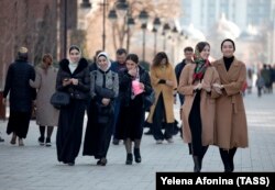Women walk down a street in the Chechen capital, Grozny. There have been reports that police have been stopping people in Chechnya and checking their phones for evidence they are subscribed to 1ADAT.