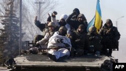 Ukrainian soldiers ride an armored personnel carrier as they leave the eastern Ukrainian city of Debaltseve on February 18.