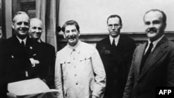 Йоахім фон Ріббентроп (ліворуч), заступник державного секретаря Німеччини Фрідріх Гаус (другий зліва), керівник СРСР Йосип Сталін (3-й) та радянський міністр закордонних справ В'ячеслав Молотов (праворуч) у день підписання «пакту Молотова-Рібентропа», 23 серпня 1939 року